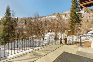 Snow covered patio with a mountain view and fence