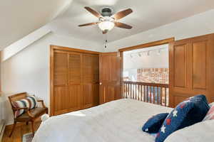 Bedroom with ceiling fan, baseboard heating, a closet, and wood finished floors