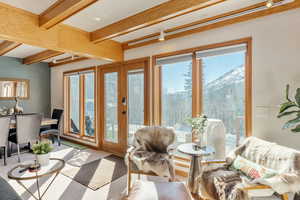 Sunroom / solarium featuring a mountain view, beamed ceiling, and french doors