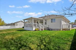 Back of property with central AC unit, fence, and a yard