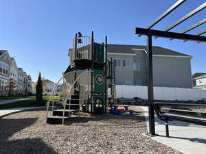 Community jungle gym featuring a residential view and fence