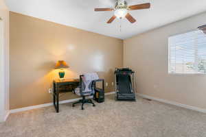 Home office with visible vents, ceiling fan, carpet flooring, and baseboards