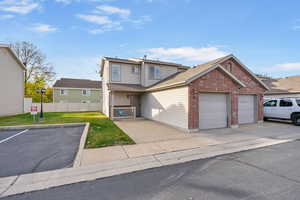 Traditional home featuring a front yard, an attached garage, fence, and brick siding