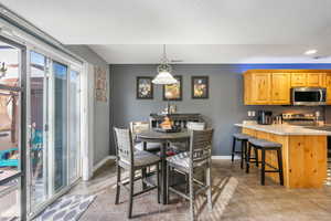 Dining space featuring light tile patterned floors, baseboards, and a textured ceiling