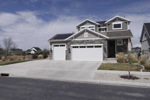 Craftsman house with a shingled roof, solar panels, an attached garage, stone siding, and concrete driveway RV Parking on side
