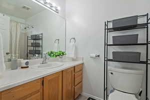 Bathroom featuring visible vents, toilet, vanity, and baseboards