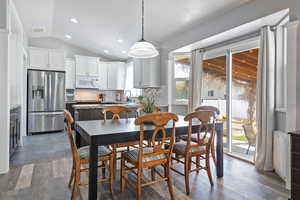 Dining space featuring wood finished floors, visible vents, vaulted ceiling, and recessed lighting