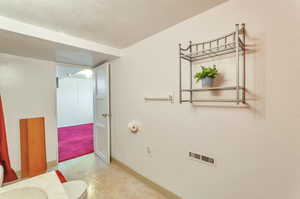 Bathroom with baseboards, tile patterned floors, a textured ceiling, and visible vents