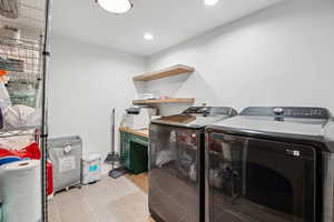 Clothes washing area featuring recessed lighting, light tile patterned floors, separate washer and dryer, and laundry area