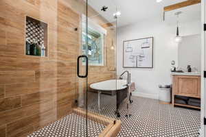 Full bath featuring a freestanding tub, a stall shower, and vanity