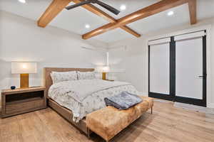 Bedroom with light wood finished floors, baseboards, beam ceiling, and recessed lighting