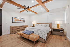 Bedroom with light wood-type flooring, visible vents, baseboards, and beamed ceiling