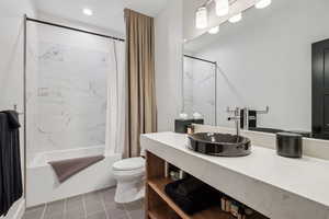 Bathroom featuring toilet, shower / bath combo with shower curtain, vanity, and recessed lighting