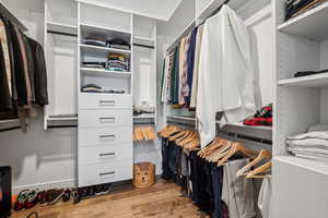 Walk in closet with wood finished floors