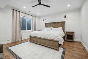 Bedroom with visible vents, baseboards, a ceiling fan, and wood finished floors