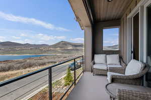 Balcony featuring a water and mountain view