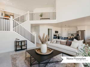 Living area featuring stairway, a towering ceiling, light colored carpet, and baseboards
