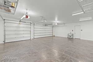 Garage featuring a garage door opener, a sink, and baseboards
