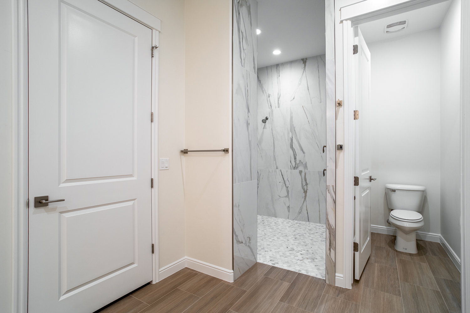 Bathroom with baseboards, toilet, recessed lighting, wood finish floors, and a marble finish shower