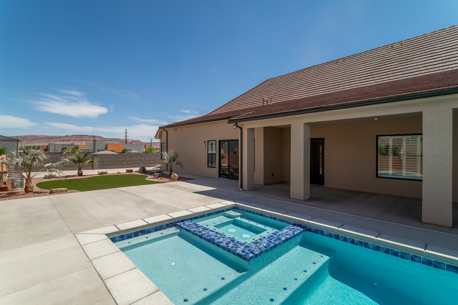 View of swimming pool with a patio, a pool with connected hot tub, and fence