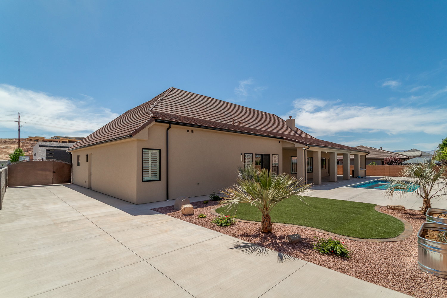 Rear view of house featuring a patio, stucco siding, a gate, a tiled roof, and fence