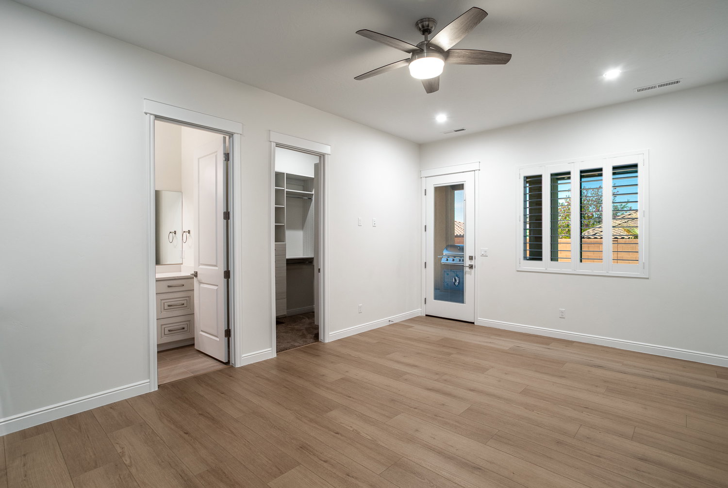 Unfurnished bedroom with light wood-style flooring, ensuite bathroom, a walk in closet, and visible vents