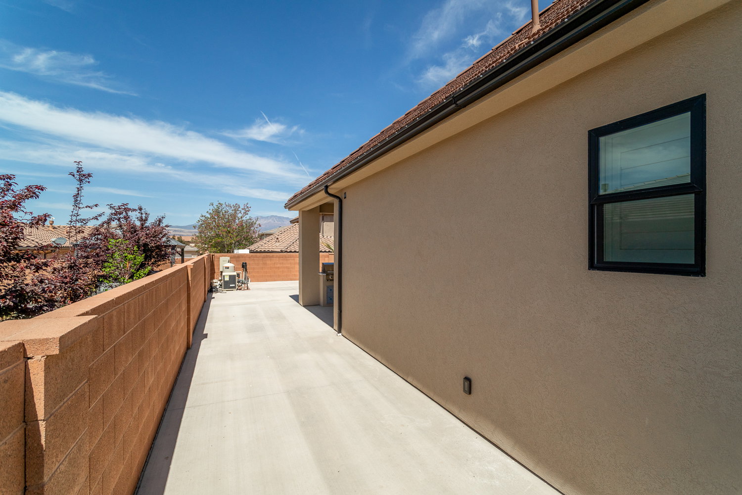 View of home's exterior with a patio area, fence, and stucco siding