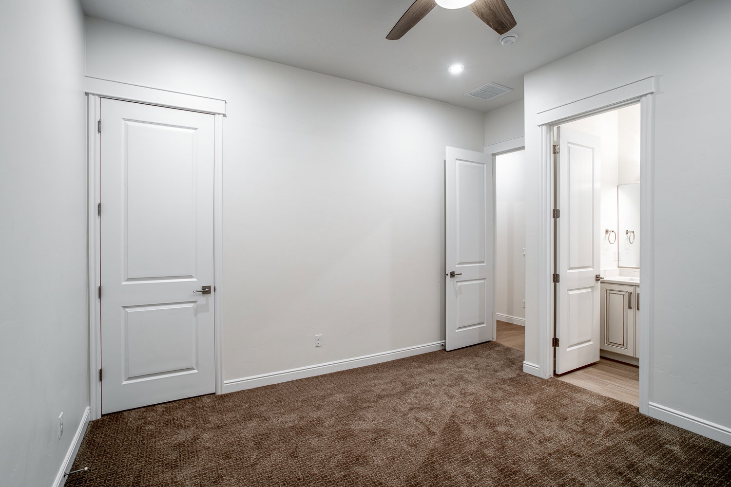 Unfurnished bedroom with visible vents, baseboards, and light colored carpet