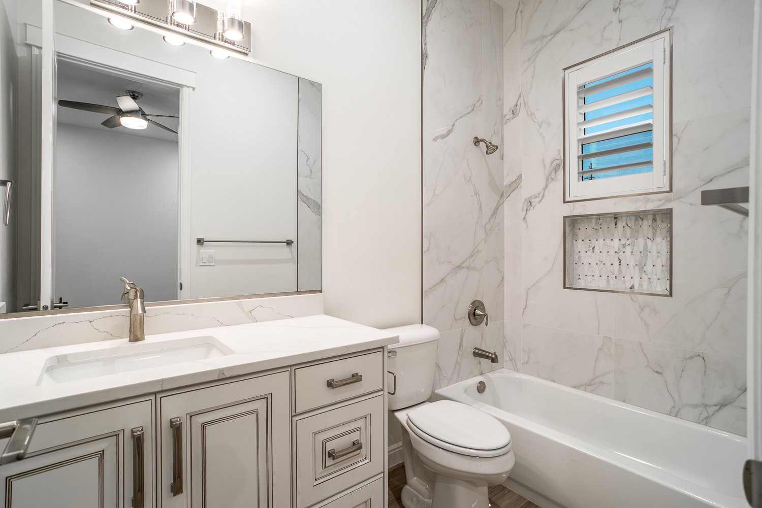 Bathroom featuring toilet, ceiling fan, vanity, and shower / washtub combination