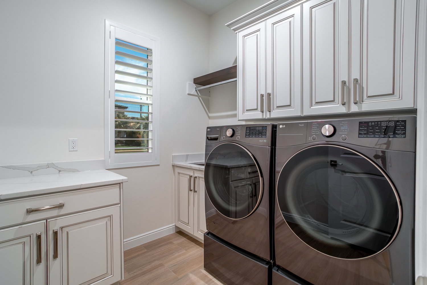 Laundry area with light wood finished floors, independent washer and dryer, baseboards, and cabinet space