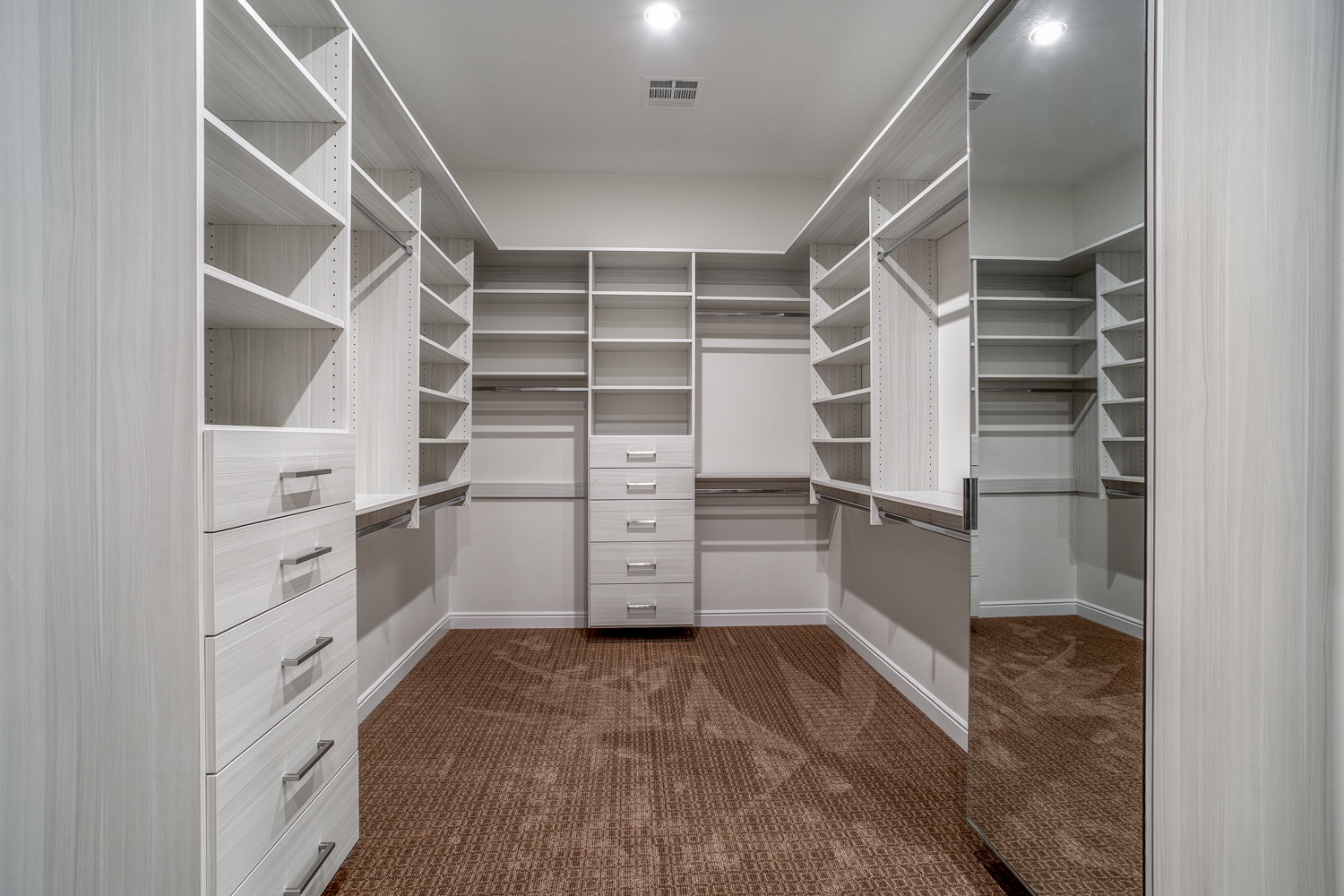 Spacious closet featuring visible vents and dark carpet