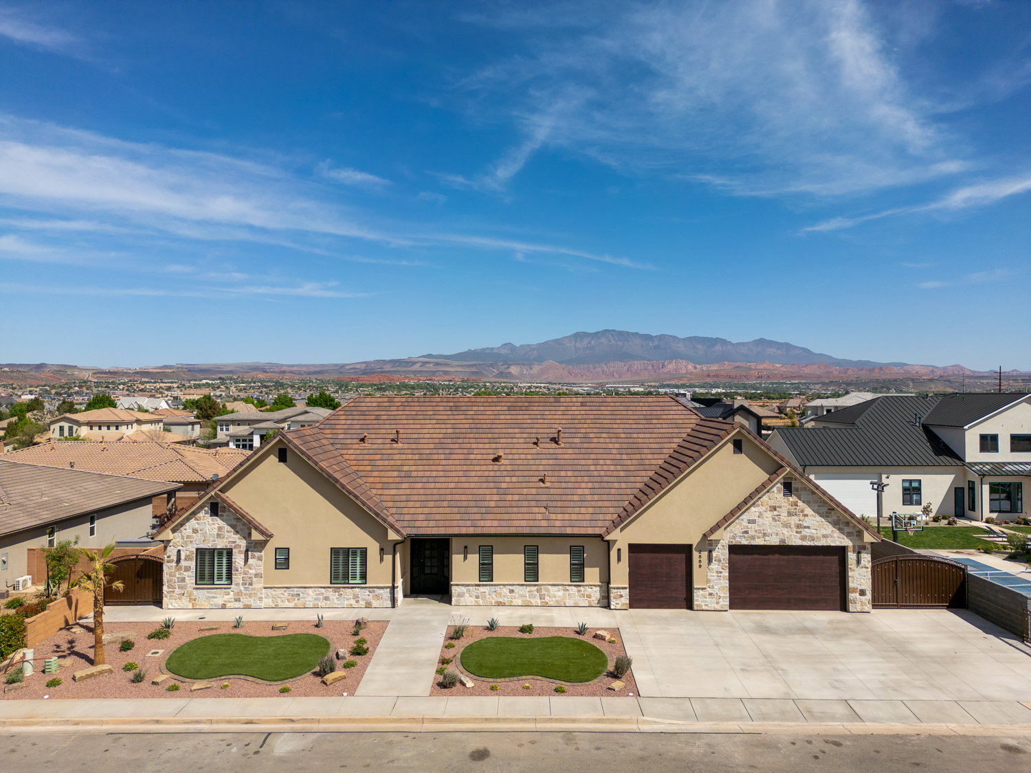 Ranch-style house featuring stone siding, driveway, and stucco siding