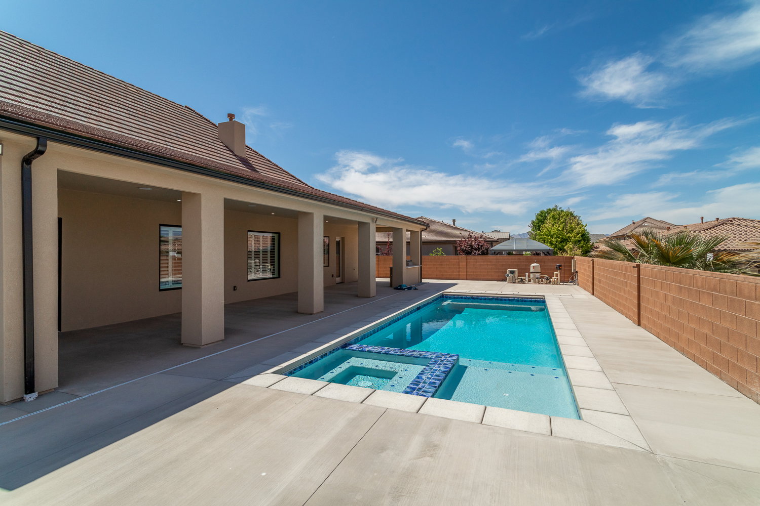 View of pool featuring a fenced backyard, a pool with connected hot tub, and a patio