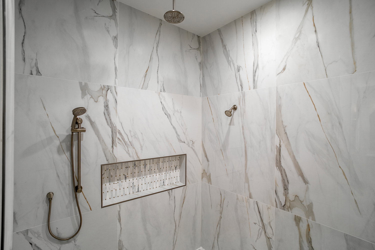 Full bath with a marble finish shower