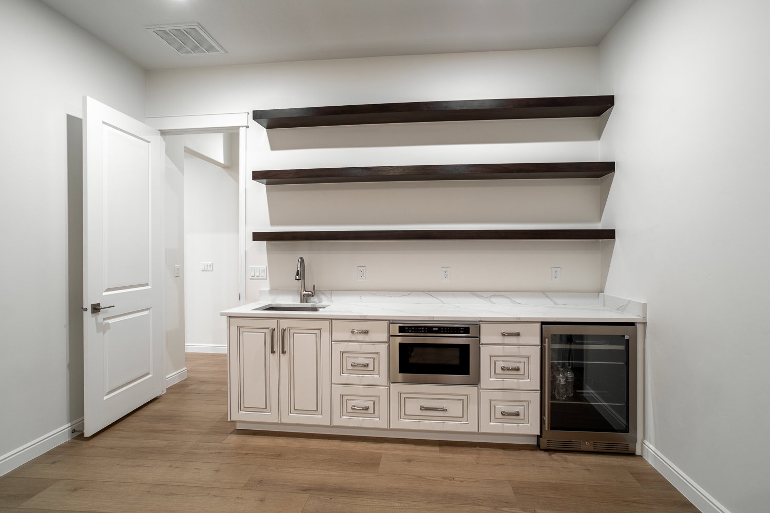 Bar with wet bar, visible vents, oven, beverage cooler, and a sink