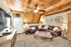 Living area featuring light carpet, wooden ceiling, beamed ceiling, and a healthy amount of sunlight