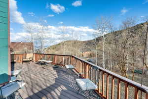 Upper Wooden terrace featuring a mountain view