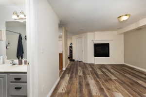 Interior space with a sink, visible vents, baseboards, and dark wood finished floors
