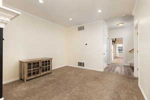 Carpeted spare room with ornamental molding, visible vents, and recessed lighting
