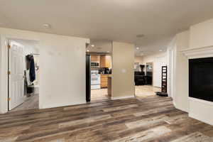 Unfurnished living room featuring baseboards, recessed lighting, and wood finished floors