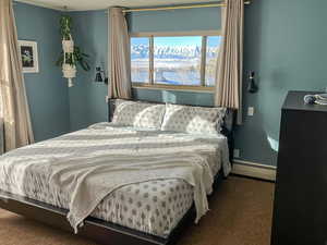 Carpeted bedroom with baseboard heating