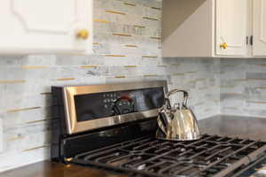Kitchen featuring gas range and white cabinetry