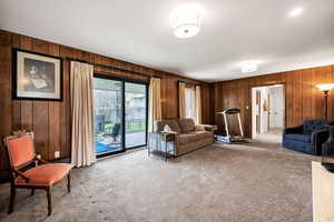 Living room featuring wood walls and light carpet