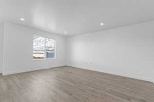 Unfurnished room featuring light wood finished floors, baseboards, and recessed lighting