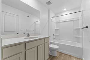 Full bathroom with toilet, wood finished floors, vanity, and visible vents