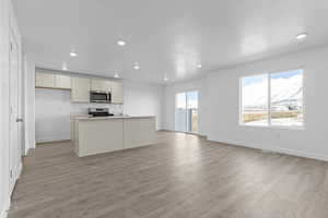Unfurnished living room featuring baseboards, recessed lighting, and light wood-style floors