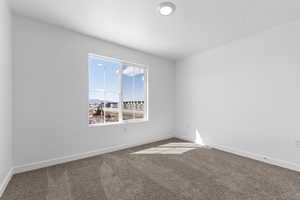 Empty room featuring baseboards and carpet