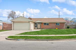 Ranch-style home with concrete driveway, a front lawn, brick siding, a garage, and fence