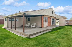 Rear view of house with a patio and a yard