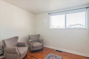 Living area featuring wood finished floors, baseboards, and visible vents